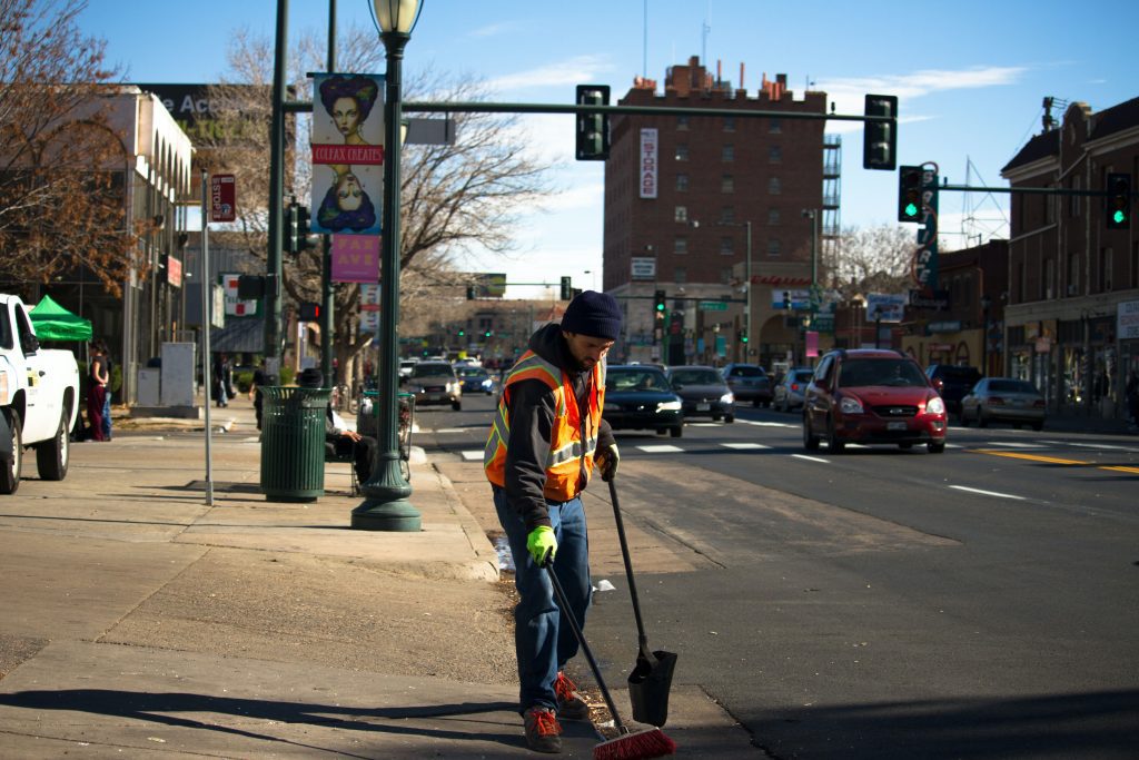 Person picking up trash from the street