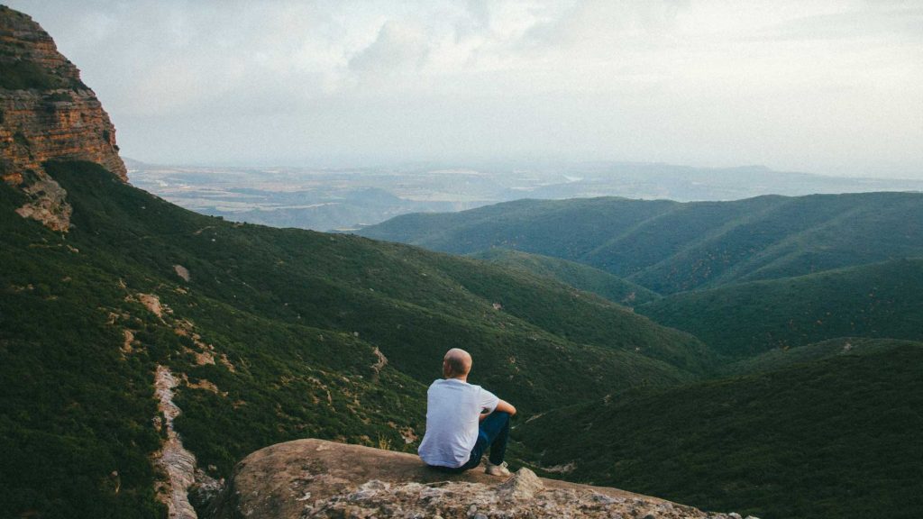 entrepreneur sitting on a hill looking into the distance